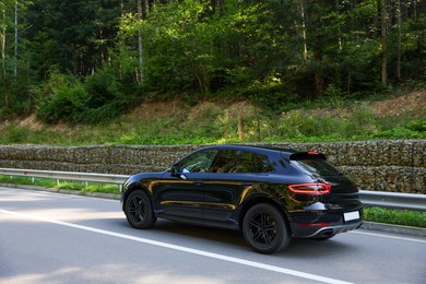 Picturesque view of asphalt road with modern black car