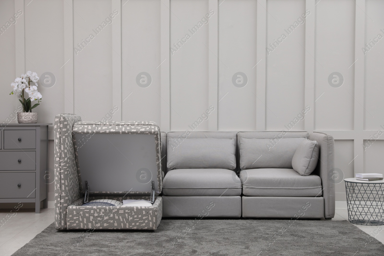 Photo of Modular sofa in living room, open section with storage. Interior design