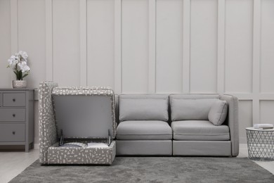 Photo of Modular sofa in living room, open section with storage. Interior design