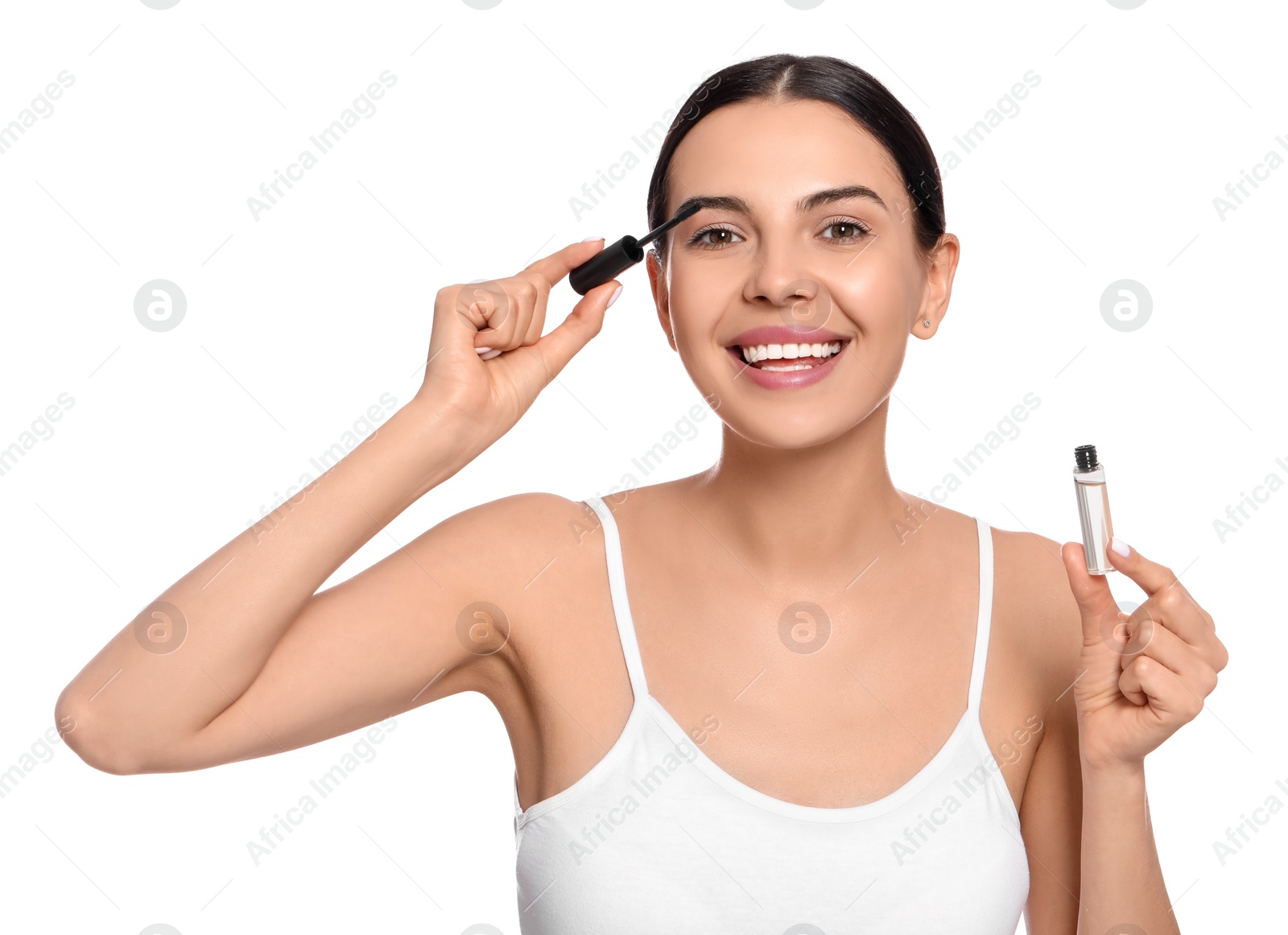 Photo of Young woman applying oil onto eyelashes on white background