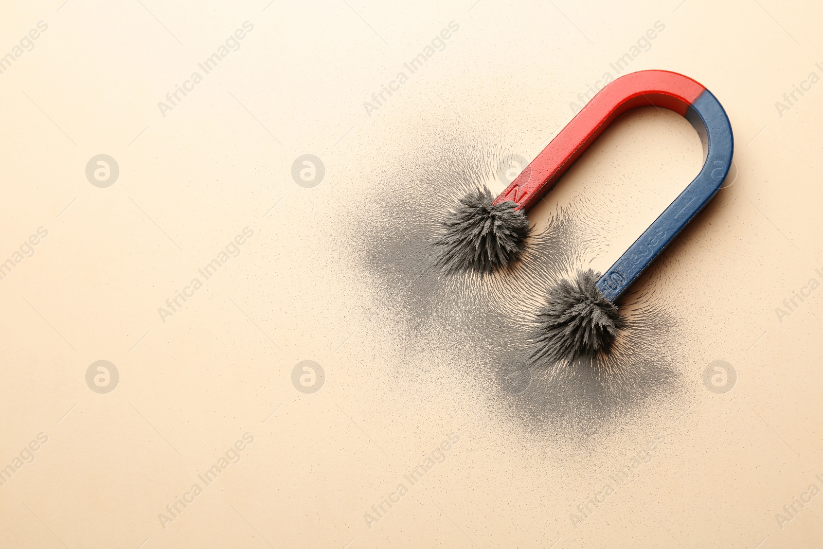 Photo of Magnet with iron powder on color background, top view. Space for text