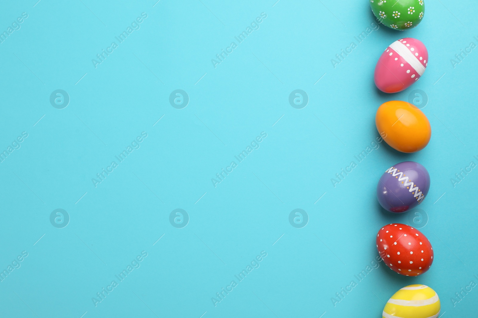 Photo of Decorated Easter eggs and space for text on color background, top view