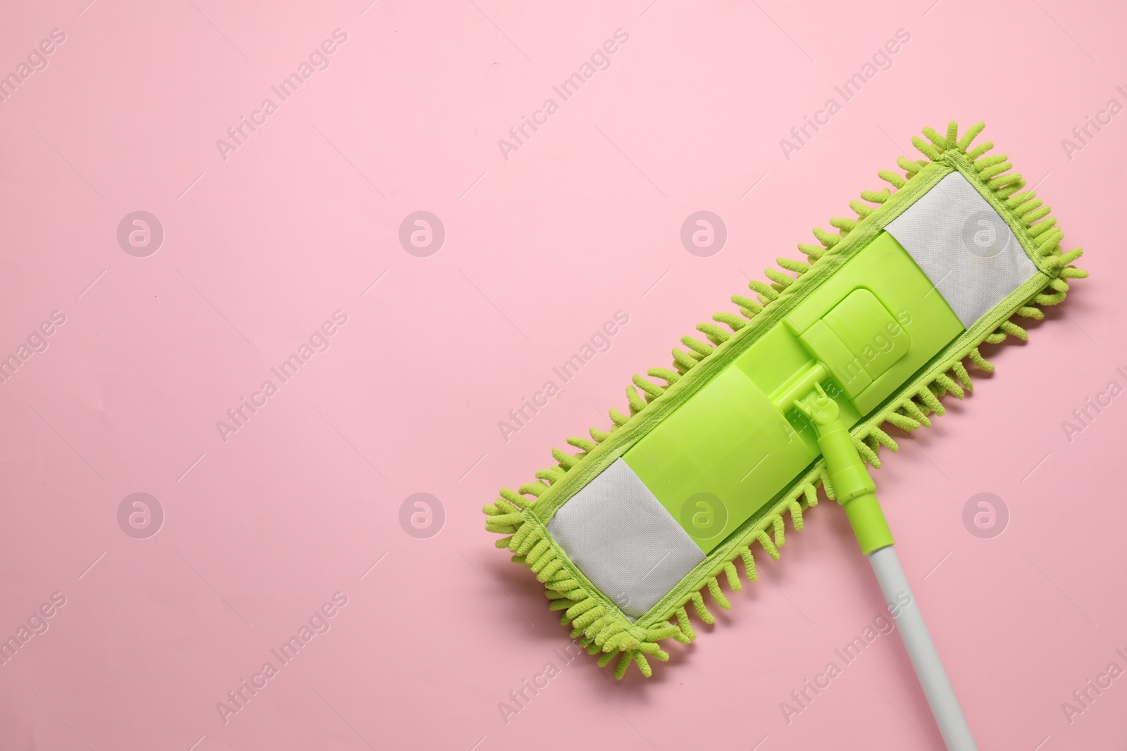 Photo of Mop with plastic handle on pink background, top view. Space for text