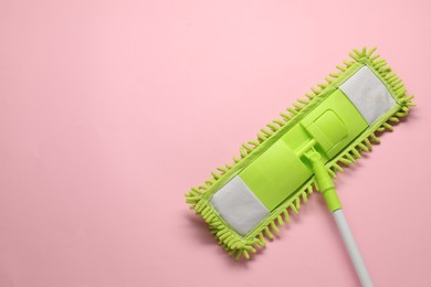 Mop with plastic handle on pink background, top view. Space for text