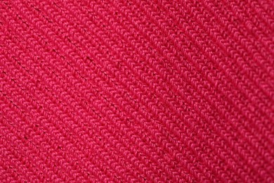 Texture of soft red knitted fabric as background, top view