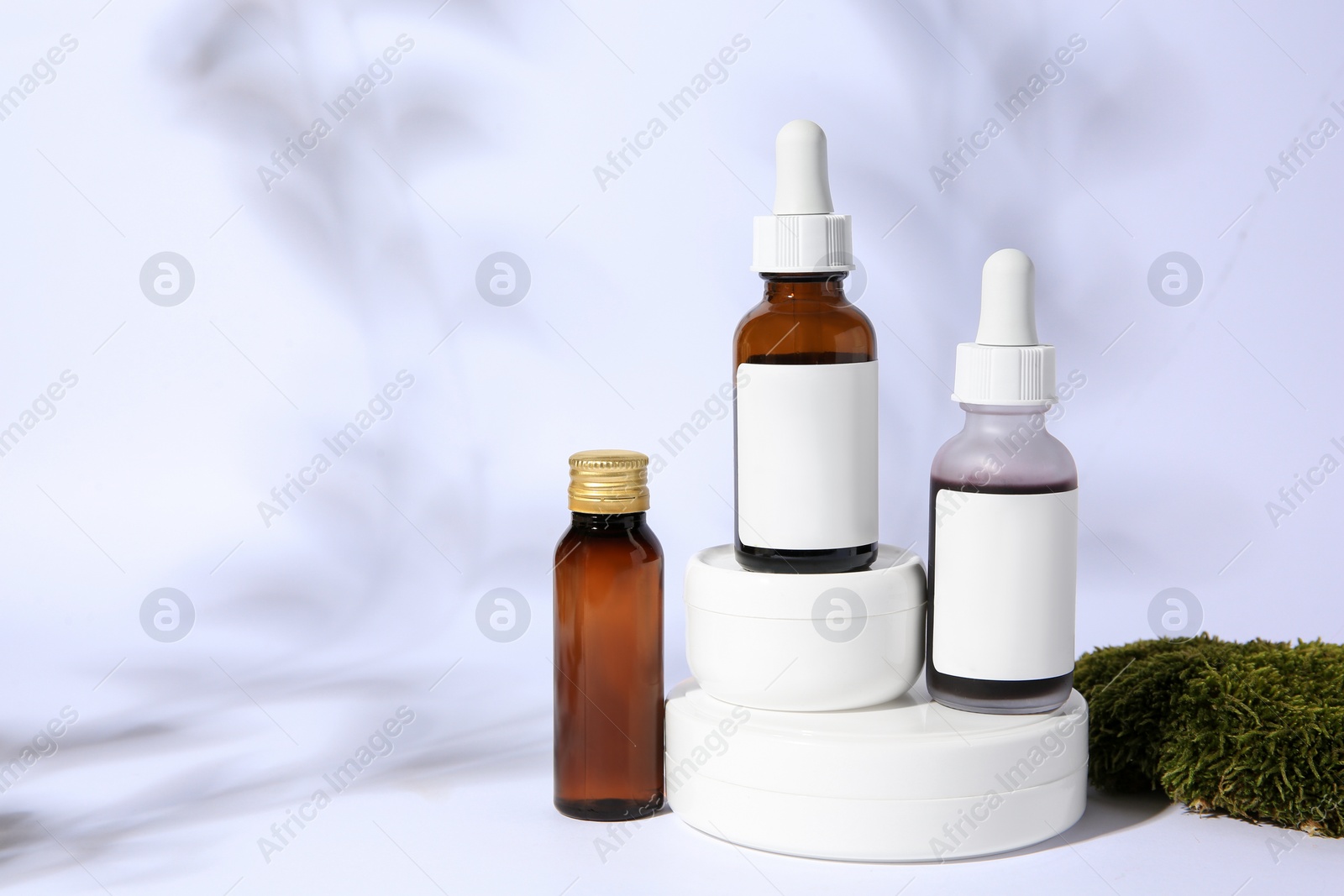 Photo of Cosmetic products and green moss on white background. Space for text