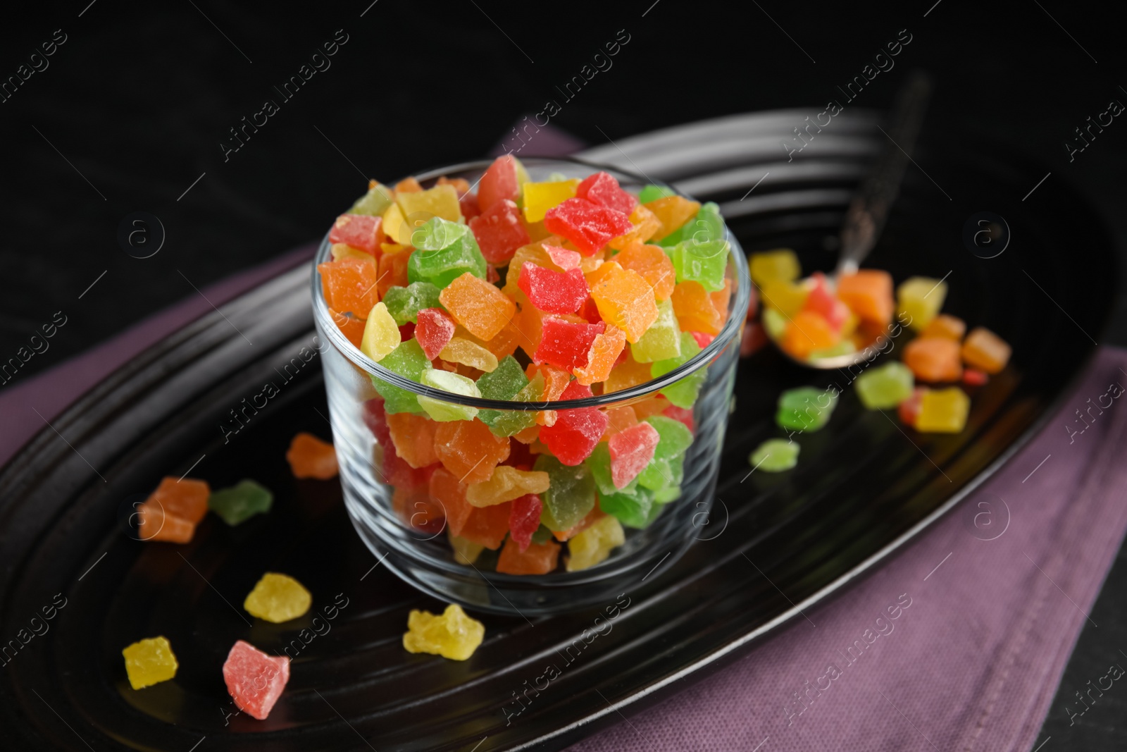 Photo of Tray with mix of delicious candied fruits on table, closeup
