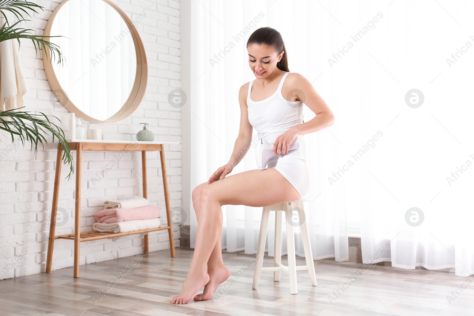 Photo of Young woman doing leg epilation procedure indoors. Space for text