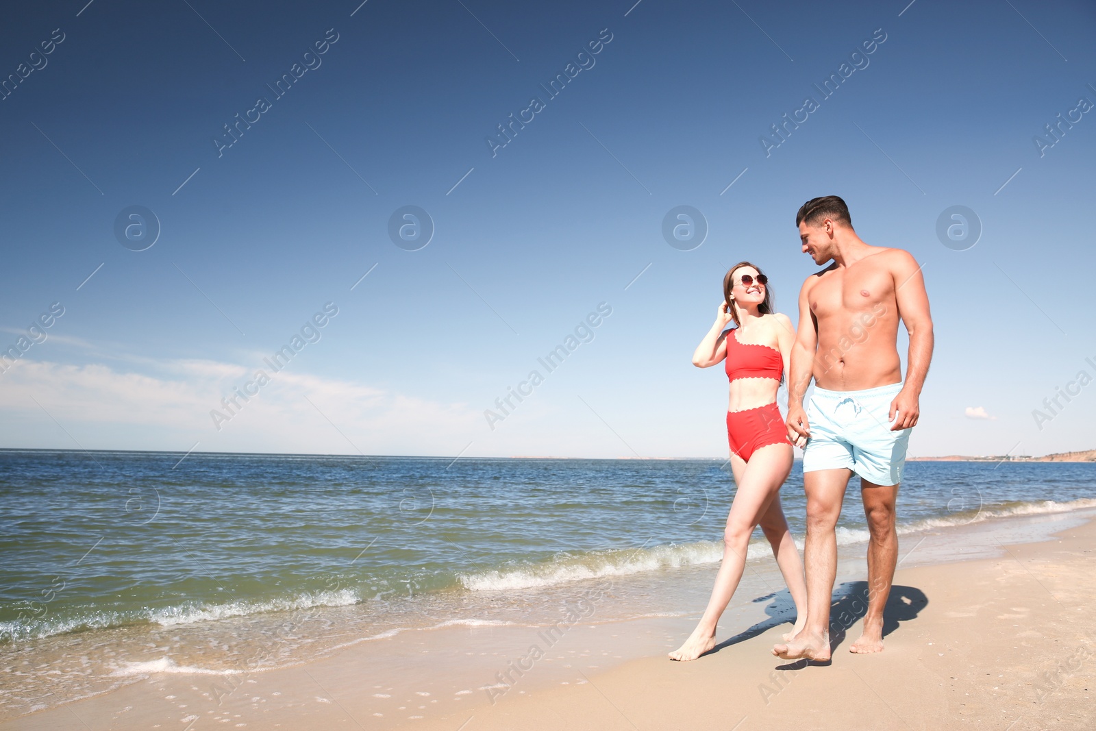 Photo of Woman in bikini and her boyfriend on beach, space for text. Happy couple