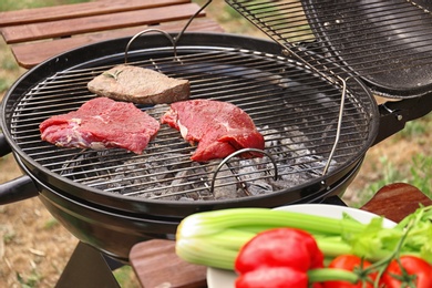 Tasty meat on barbecue grill outdoors, closeup