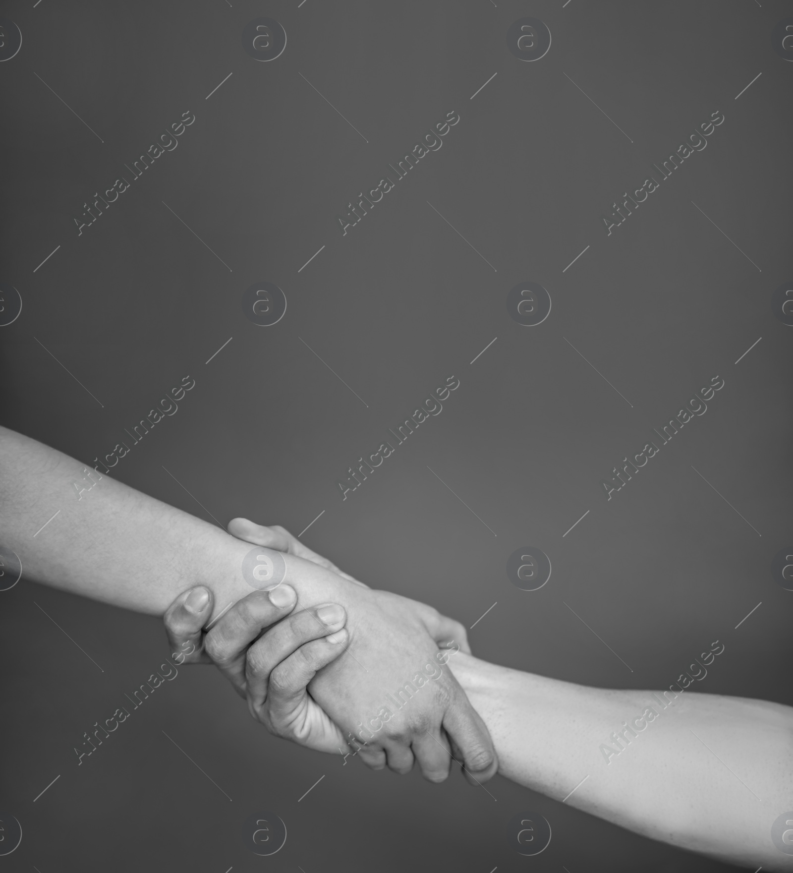 Photo of Man and woman holding hands together on grey background, black and white effect. Unity concept