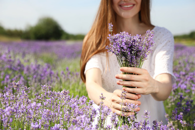 Photo of Young woman with lavender bouquet in field on summer day, closeup