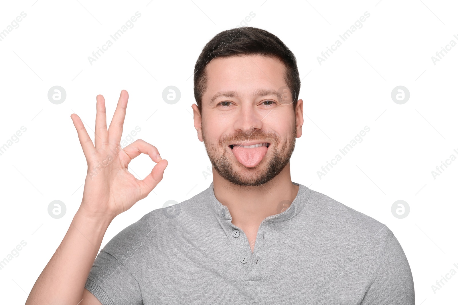 Photo of Happy man showing his tongue and OK gesture on white background