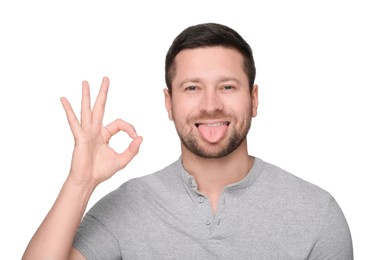 Happy man showing his tongue and OK gesture on white background