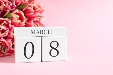 Photo of International Women's day - 8th of March. Block calendar and bouquet of beautiful tulips on pink background. Space for text