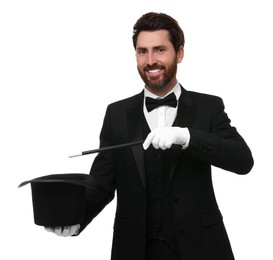 Photo of Happy magician showing magic trick with top hat on white background