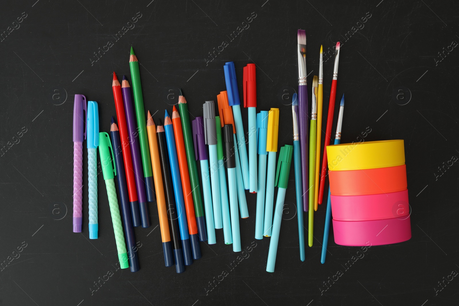 Photo of Different stationery on blackboard, flat lay. Back to school