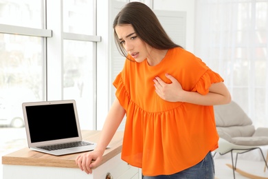 Photo of Young woman suffering from heart attack at home