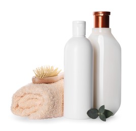 Bottles of shampoo, terry towel and wooden brush on white background