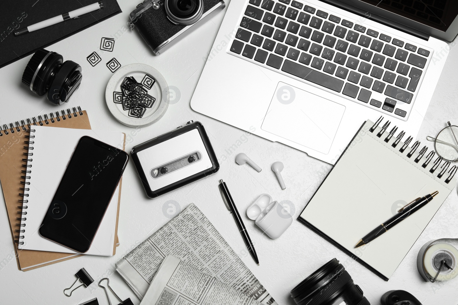 Photo of Flat lay composition with equipment for journalist on white table