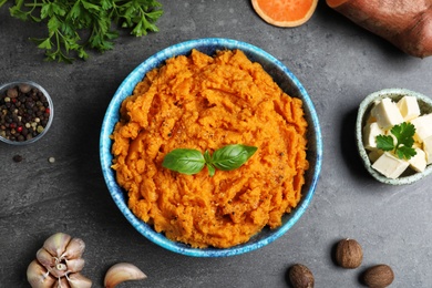 Photo of Flat lay composition with bowl of sweet potato puree on grey table