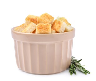 Photo of Delicious crispy croutons in bowl and rosemary on white background