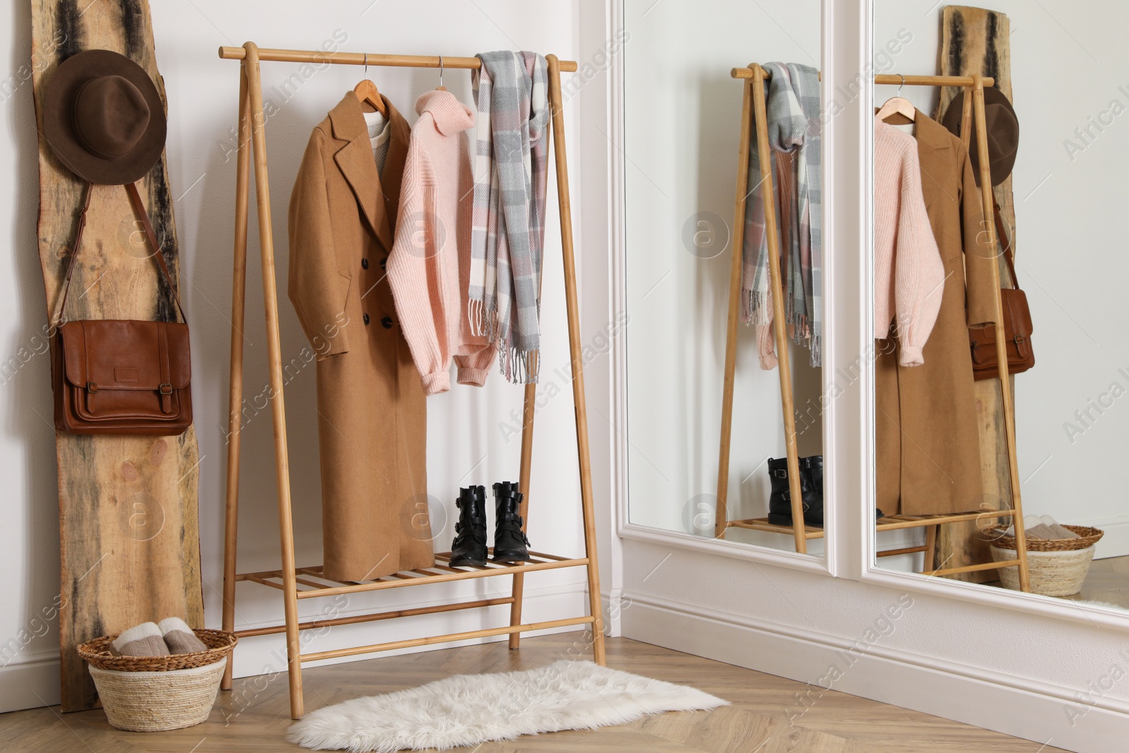 Photo of Stylish warm clothes on rack in dressing room interior