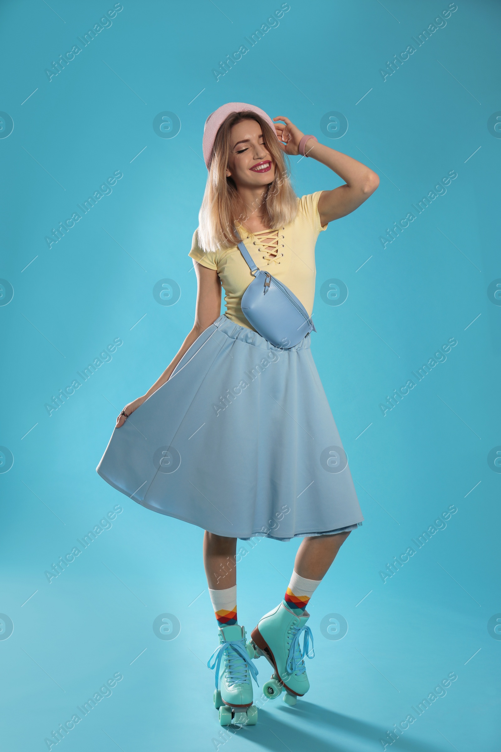 Photo of Young woman with retro roller skates on color background