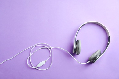 Photo of Stylish headphones on color background, top view. Space for text