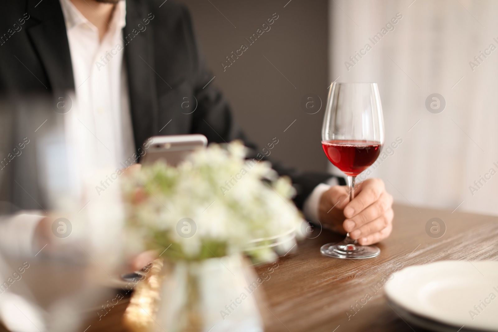 Photo of Man with glass of wine at table in restaurant