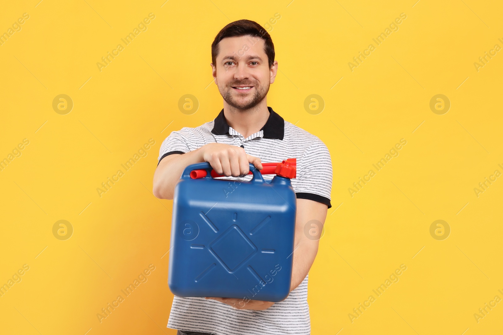 Photo of Man holding blue canister on orange background