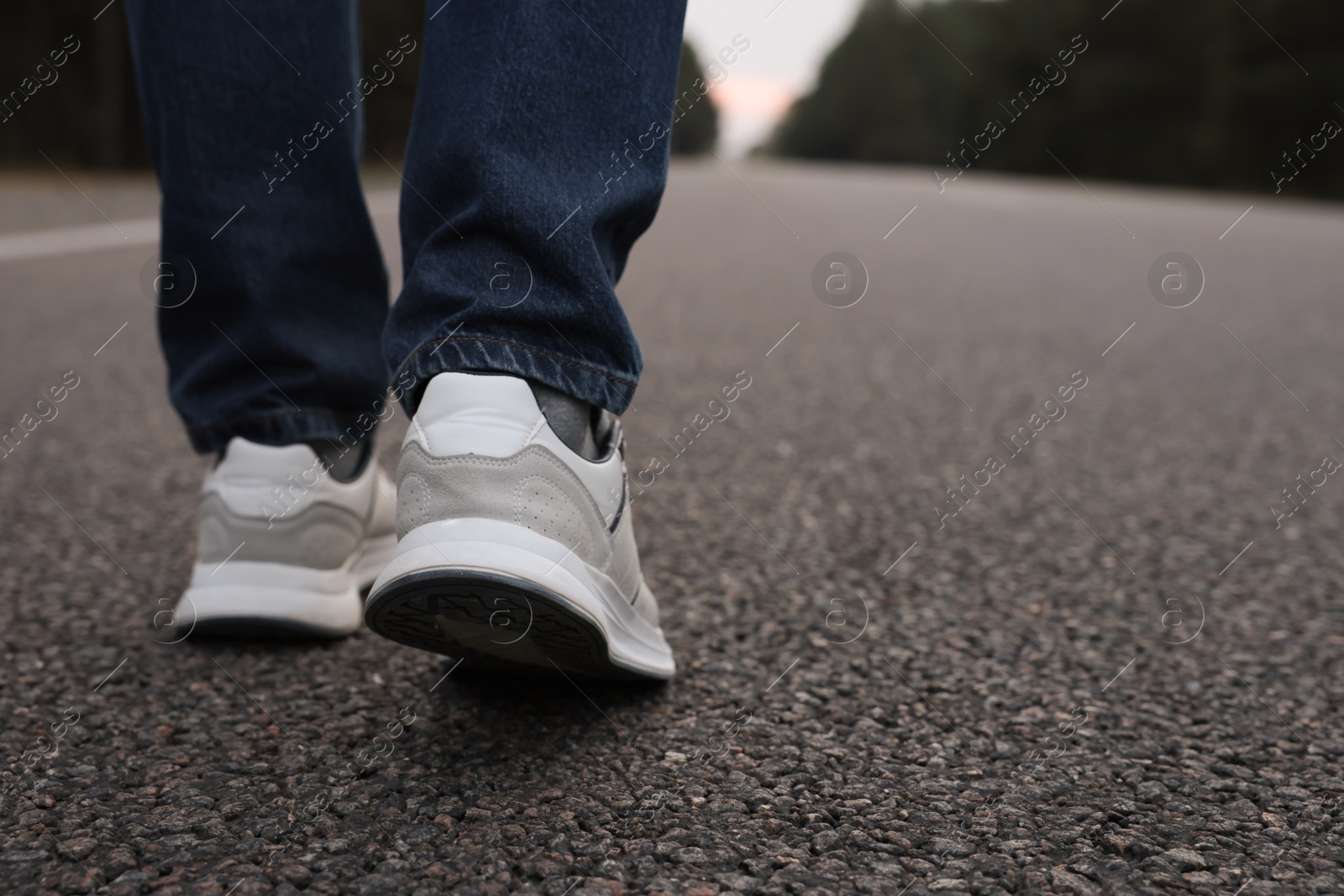 Photo of Man going along road, closeup of legs