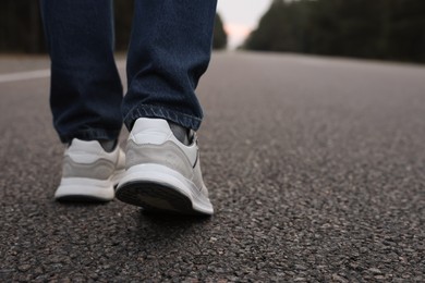 Photo of Man going along road, closeup of legs