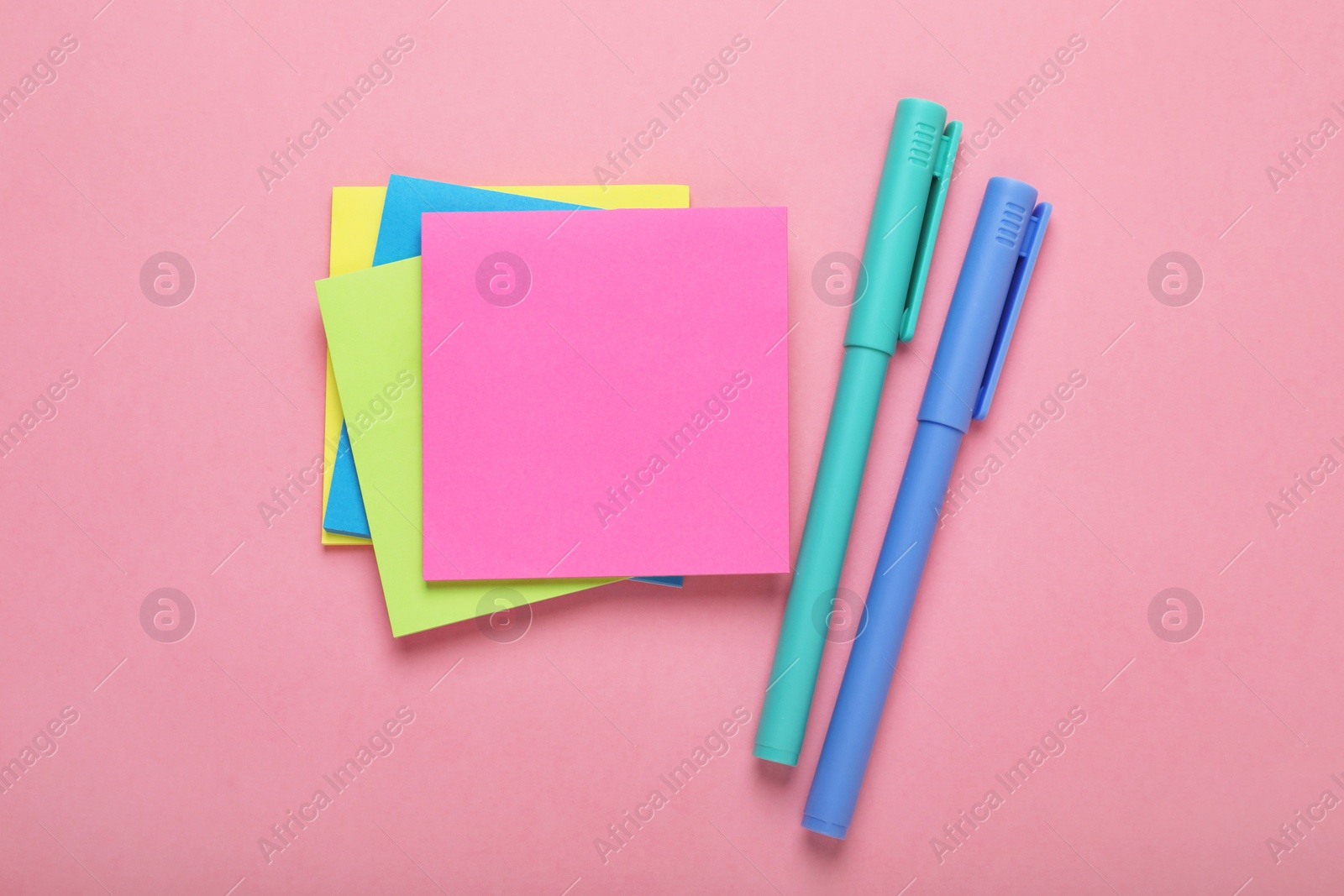 Photo of Paper notes and colorful markers on pink background, flat lay