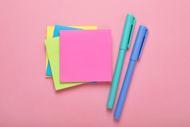 Photo of Paper notes and colorful markers on pink background, flat lay