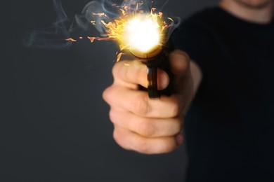 Image of Man shooting handgun on grey background, closeup