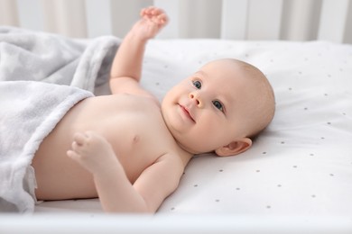 Photo of Cute little baby lying in crib at home