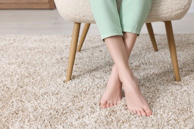 Woman on soft light brown carpet at home, closeup. Space for text