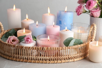 Composition with burning candles on light grey table