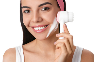 Photo of Young woman using facial cleansing brush on white background, closeup. Washing accessory