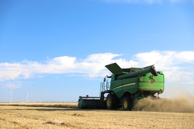 Photo of Modern combine harvester working in agricultural field