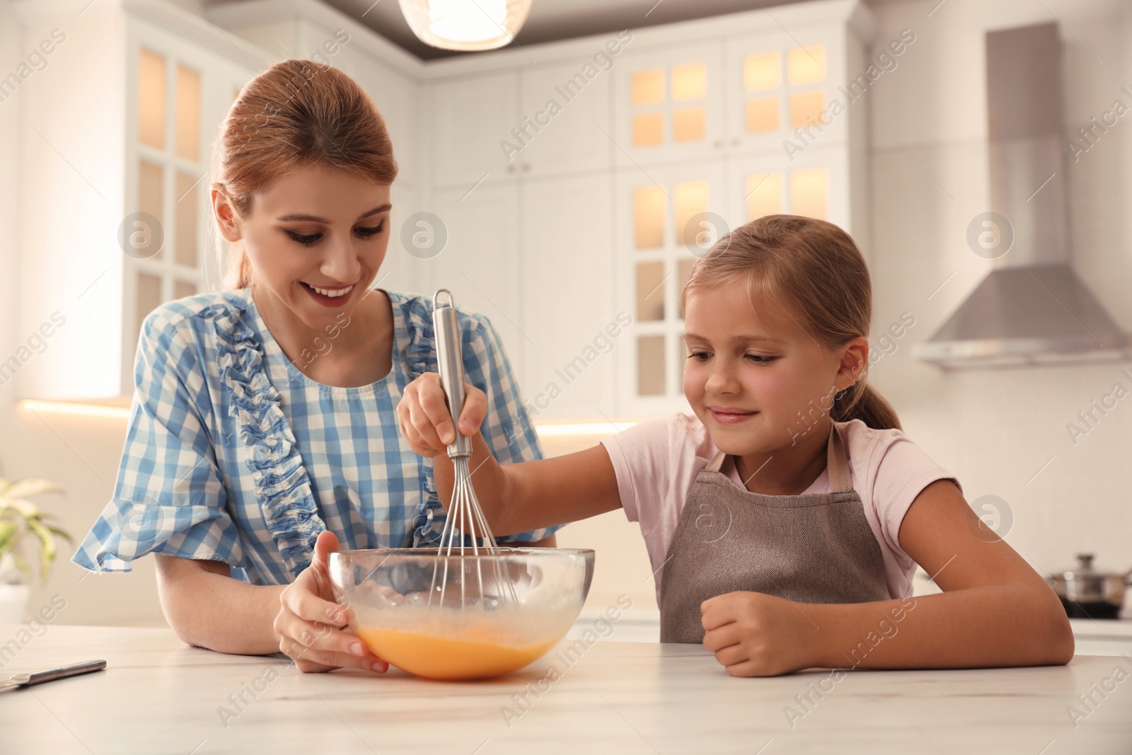 Photo of Mother and daughter making dough together in kitchen