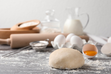 Wheat dough and products on grey table, space for text. Cooking pastries