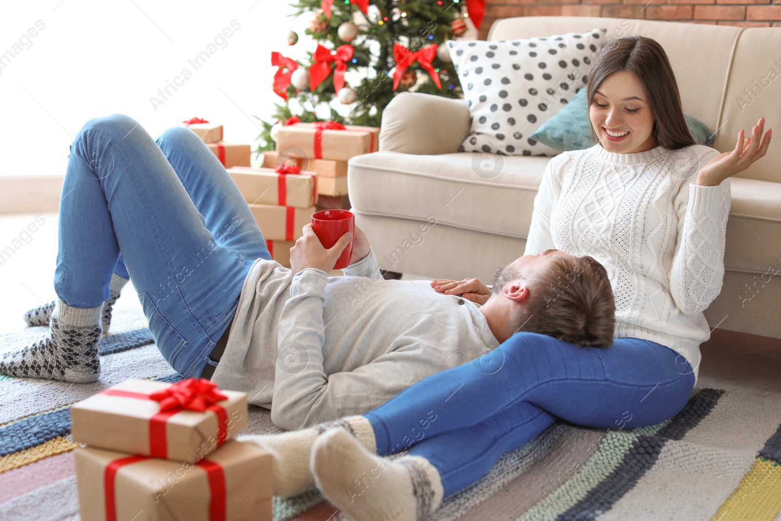 Photo of Happy young couple celebrating Christmas at home