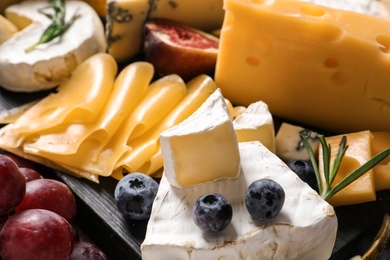 Photo of Composition with different delicious cheeses and fruits, closeup