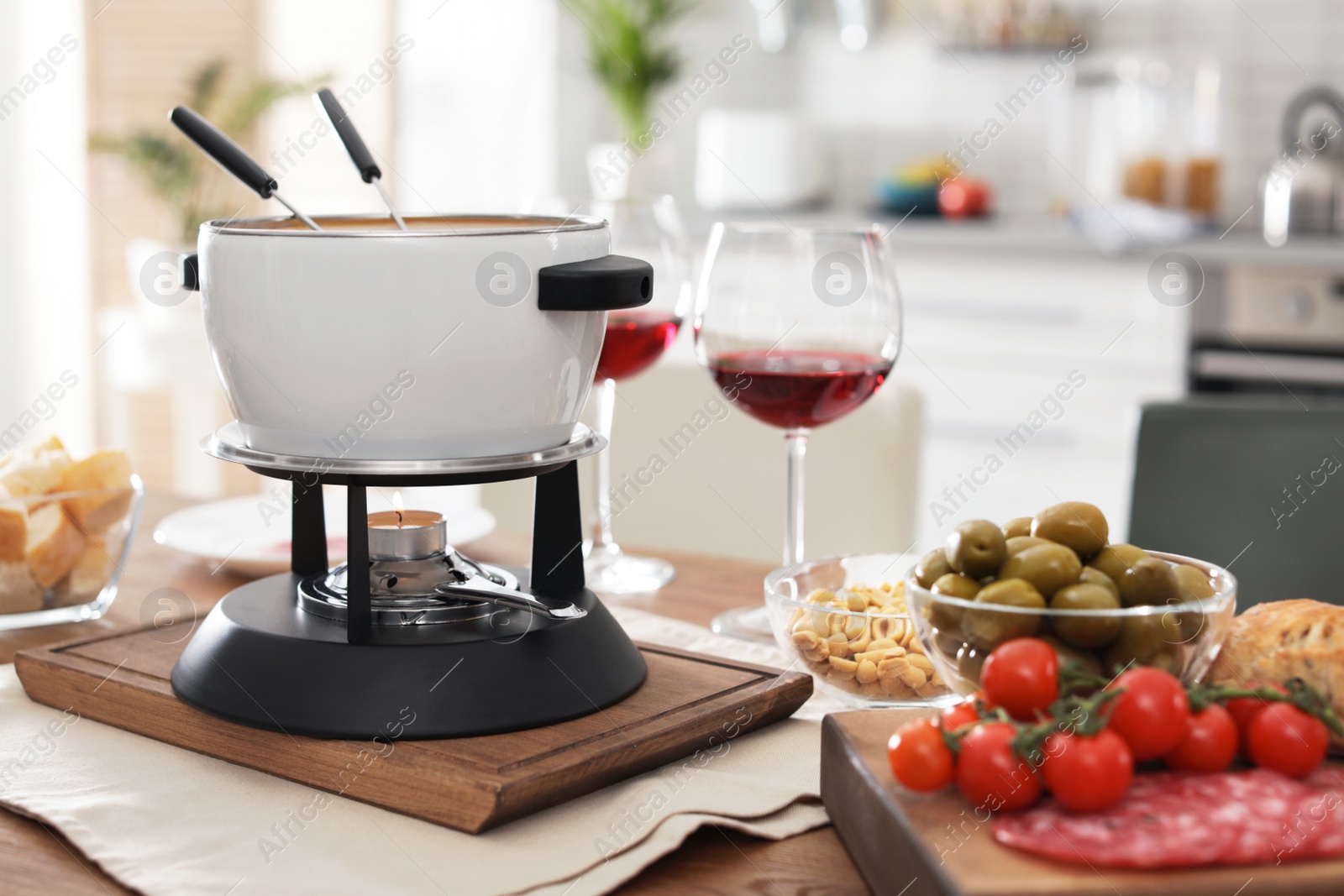 Photo of Fondue pot and different products on table indoors