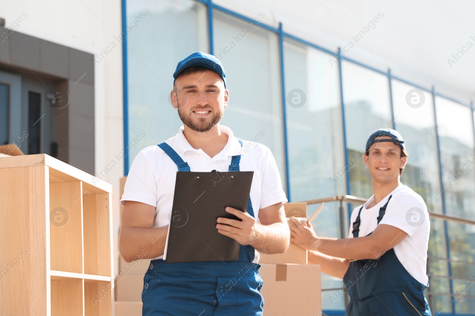 Photo of Male mover with clipboard outdoors on sunny day