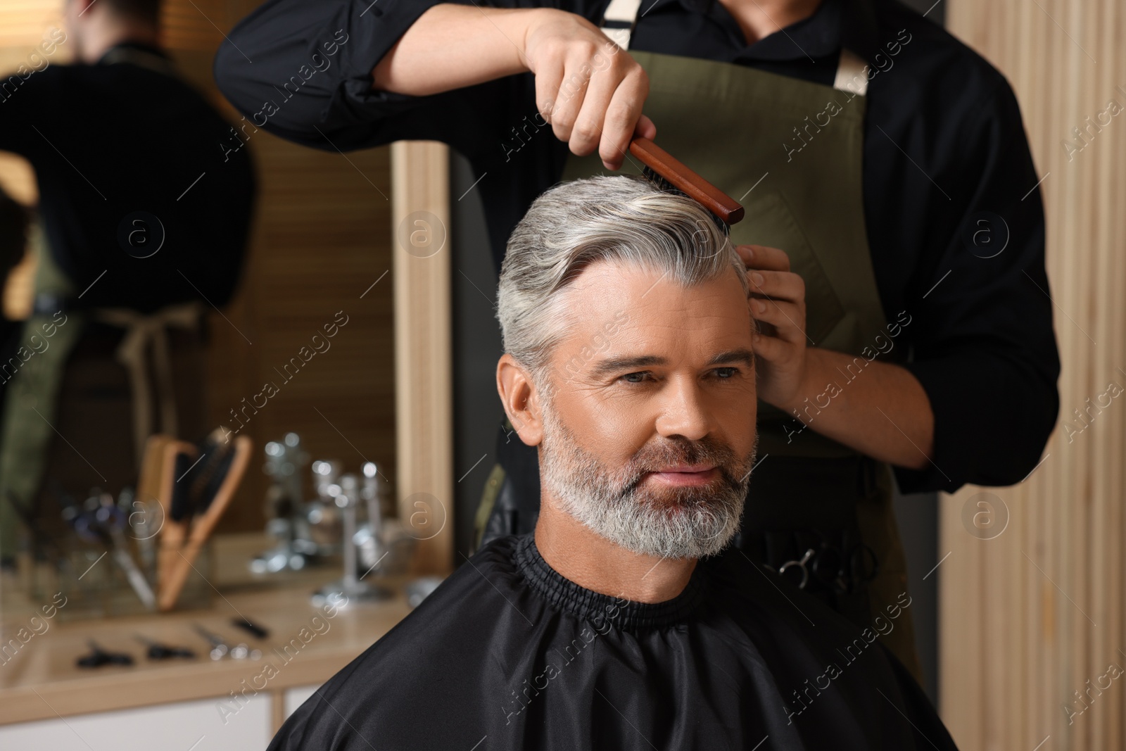 Photo of Hair styling. Professional hairdresser working with client in barbershop, closeup