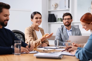 Photo of Team of employees working together in office