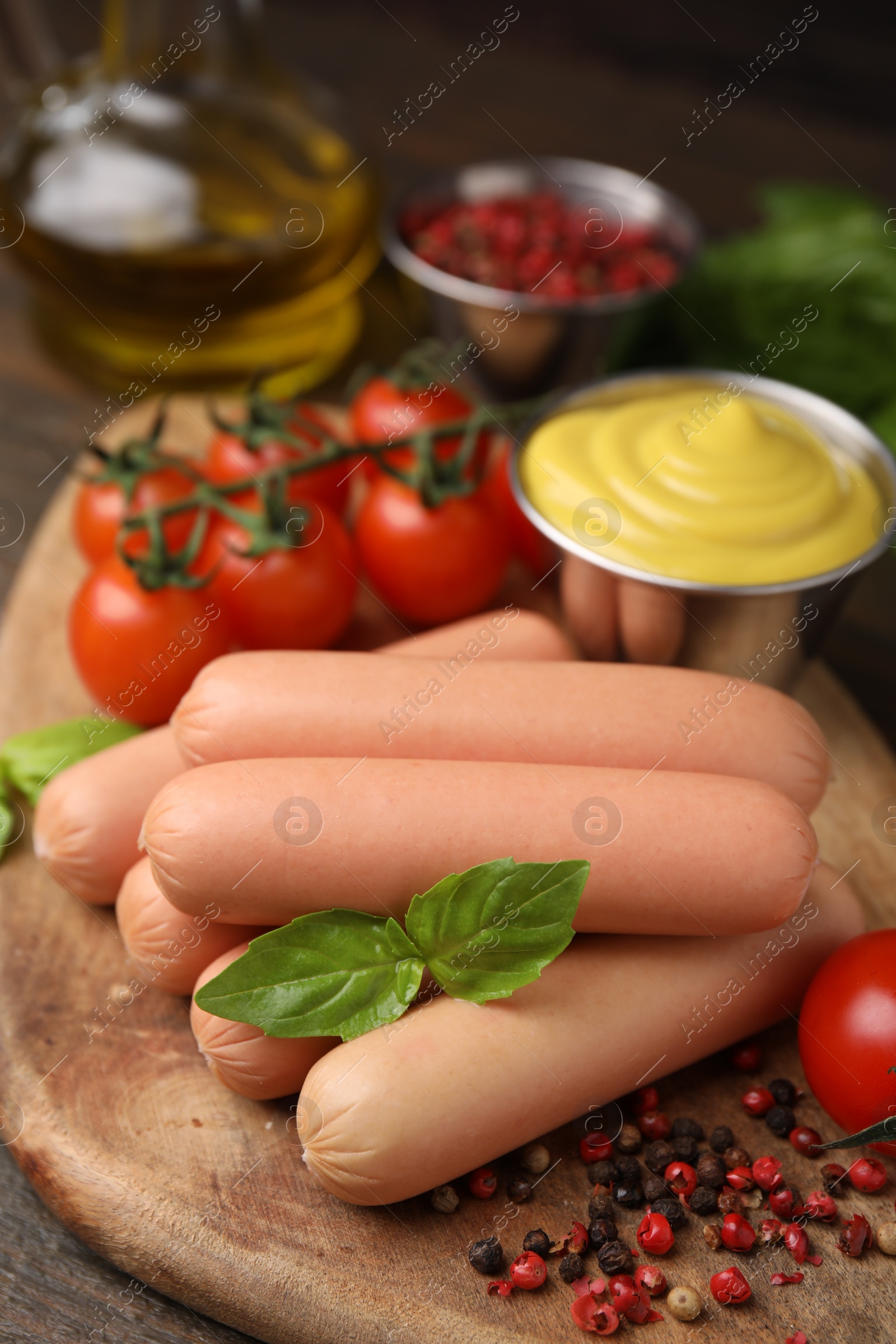 Photo of Delicious boiled sausages, sauce, tomatoes and spices on table, closeup